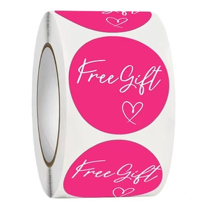 Roll of bright pink round Free Gift stickers with white script and heart for gift packaging