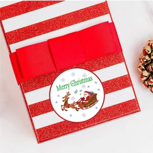 Christmas round adhesive stickers with Santa and reindeer on a festive red gift box