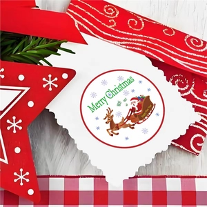 Close-up of Santa Claus sleigh stickers on white card with festive pine and wood background