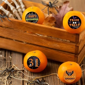 Detail of Happy Halloween round stickers applied on oranges for festive party decoration