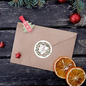 Detalle de la pegatina Joy navideña en un sobre de papel kraft para envolver regalos