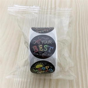 Close-up of motivational cartoon reward stickers roll with colorful text on black background