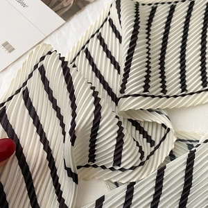 Detail of plissé pleated texture on a minimalist black and white striped silk scarf