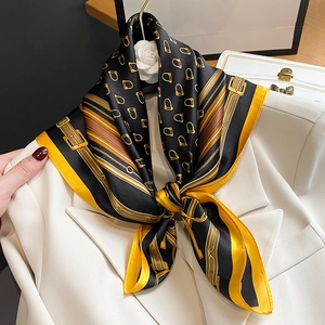 Luxurious silk scarf with equestrian chain print paired with a beige blazer jacket