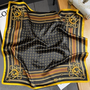 Equestrian pattern silk square scarf with golden yellow border on wooden surface