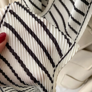 Detail of pleated black and white striped silk scarf fabric texture and micro folds