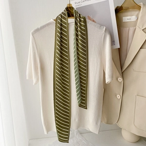 Detailed view of dark green and cream striped pleated silk scarf with soft textures