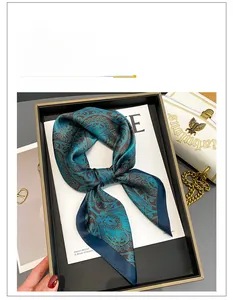 Detail of silk square scarf with blue-green paisley pattern on magazine background