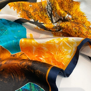 Gros plan détaillé montrant la texture satinée et l'imprimé paysage naturel du foulard
