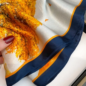 Détail d'un foulard en soie avec imprimé élan orange et texture lisse et brillante