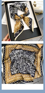 Detailed pattern of silk scarf with floral motifs and rolled edges in gold and black