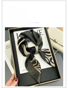 Detailed view of luxury zebra print silk scarf neatly folded in a tray on a magazine