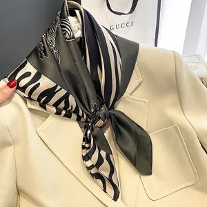 Zebra print silk scarf in dark green and beige styled on a beige professional blazer