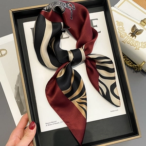 Detail of silk scarf showing zebra print in burgundy and black with a glossy finish