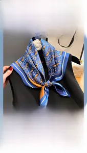 Detail of silk scarf with gold chain patterns tied on a neck for stylish look
