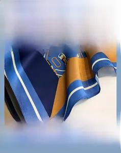 Detailed view of the fine stitched edge on a blue and gold silk square scarf