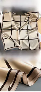 Detailed macro view of champagne silk scarf featuring brown checkered pattern and fine stitching