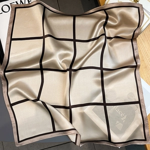 Detail shot of the champagne gold plaid silk scarf with satin finish and fine edge stitching