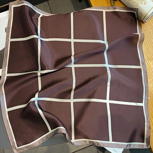 Detail shot of a chocolate brown silk scarf with wide white plaid pattern and neat edges
