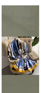 Detail of luxury silk scarf with nautical patterns draped on a beige sofa