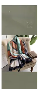 Detailed view of large silk scarf featuring retro plant leaves and chain patterns