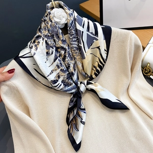 Silk square scarf featuring jungle leopard print styled on a beige knitted sweater