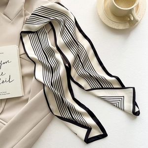 Sciarpa sottile in seta a righe bianche e nere abbinata a un blazer beige chic