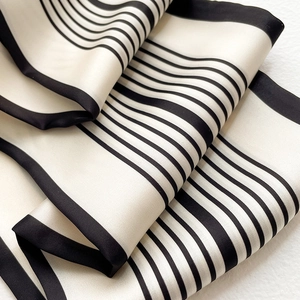 Dettaglio di un elegante foulard in seta a righe bianche e nere con finitura