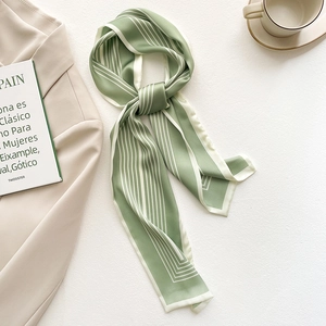 Elegante foulard in seta verde a righe da donna abbinato a un abito e un caffè