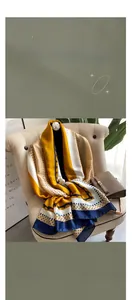 Detail of elegant satin scarf with yellow and navy geometric patterns draped over a bag