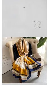 Close-up of elegant gold and navy silk scarf with polka dots and geometric patterns