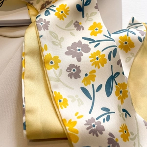 Gros plan d'un foulard en soie à fleurs avec des fleurs jaunes et une doublure jaune vif