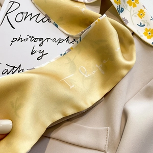 Détail d'un élégant foulard en soie à fleurs avec des panneaux jaunes et blancs fins