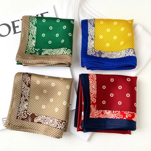 Flat lay of four colorful silk scarves featuring paisley patterns and satin luster detail