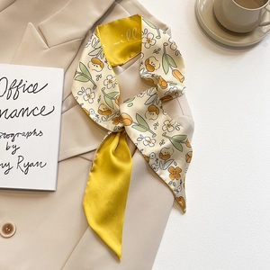 Foulard en soie fleuri de style français noué au revers d'un blazer beige élégant