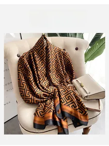 Detail of silk scarf with geometric Greek key pattern draped on a velvet sofa