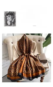 Detail of silk scarf with orange geometric pattern draped on a beige chair
