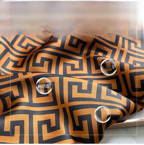 Macro detail of silk-like fabric with Greek Key pattern and smooth satin texture