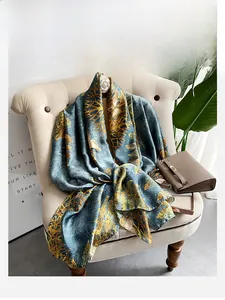 Detail of silk-feel scarf with gold palm leaf patterns draped on a vintage chair