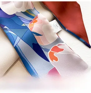 Macro shot of abstract floral printed silk scarf featuring detailed twill fabric texture