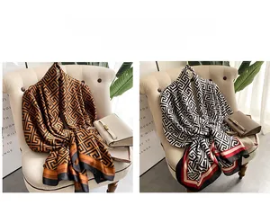 Detail of luxury geometric silk scarves draped on a chair with orange and black patterns