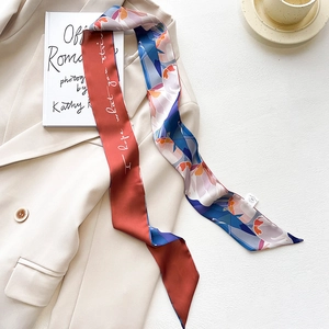 Detail of printed twilly scarf on a beige blazer featuring elegant script and floral patterns
