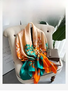 Detail of colorful leaf pattern silk scarf draped on a chair with a luxury handbag