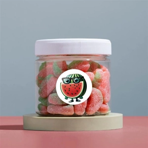 Detail showing cartoon watermelon sticker on clear gift jar with colorful soft candies