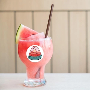 Cartoon watermelon sticker on a smoothie glass with a cozy wooden background