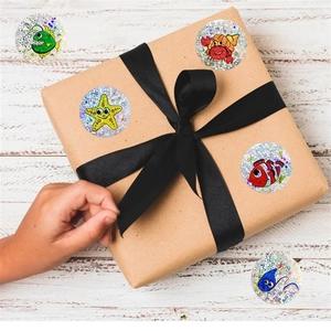 Close-up of holographic sea creature stickers on a gift box with a rustic wood background