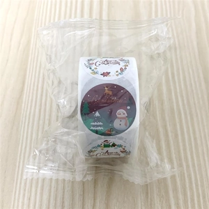 Macro shot of assorted Christmas stickers roll with festive patterns in poly bag