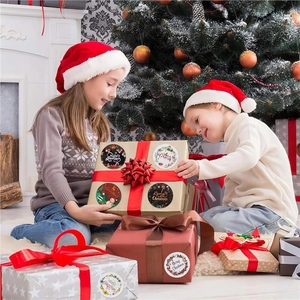 Christmas round stickers on gift boxes with children under the tree in festive setting