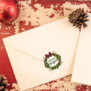 Merry Christmas wreath sticker on a cream envelope with a festive red wood background