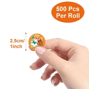 Detail of 1 inch round Merry Christmas sticker roll with 500 labels in hand